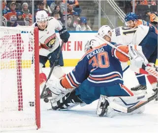  ?? JASON FRANSON/THE CANADIAN PRESS ?? Sam Reinhart scores a goal on Oilers goalie Calvin Pickard during the first period Saturday in Edmonton, Alberta.