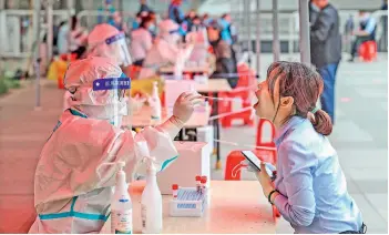  ?? — AFP ?? A health worker takes a swab sample from a resident to test for the Covid-19 in Shenyang, in northeaste­rn China’s Liaoning province on Thursday.