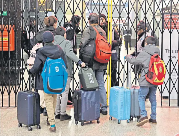  ?? ?? Travellers speak to staff at London’s Victoria Station, which was closed to the public yesterday as members of the Aslef train drivers’ union took part in a walkout that brought disruption to rail services across the country