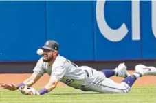  ?? Kathy Willens, The Associated Press ?? Rockies center fielder David Dahl dives for a run-scoring triple by the New York Mets’ J.D. Davis during the sixth inning Sunday at Citi Field.
