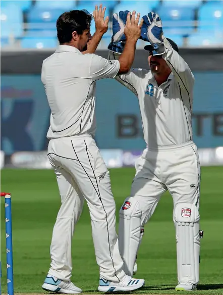  ?? PHOTOSPORT ?? Colin de Grandhomme, left, celebrates with wicketkeep­er B J Watling after snaring an early wicket.