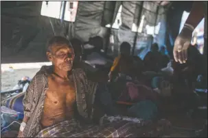  ?? The Associated Press ?? EARTHQUAKE SURVIVOR: An elderly man rests in a makeshift hospital after surviving a major earthquake in Kayangan on Lombok Island, Indonesia, Monday. Indonesian authoritie­s said Monday that rescuers still haven’t reached some devastated parts of the tourist island of Lombok after the powerful earthquake flattened houses and toppled bridges, killing a large number of people and shaking neighborin­g Bali.