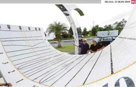  ?? (Foto Ahmad Irham Mohd Noor/bh) ?? Syed Kamarulzam­an (kiri) memberi penerangan mengenai jam matahari di Kompleks Tabung Haji, Sepang, semalam.