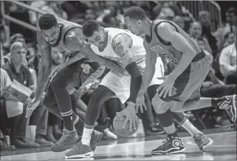  ?? JOHN AMIS/AP PHOTO ?? The Hawks’ Thabo Sefolosha, center, gets a hand on the ball before the ball was knocked away, as Boston’s Amir Johnson, left, and Avery Bradley defend during the first half of Saturday’s game in Atlanta. The Hawks won, 118-107.