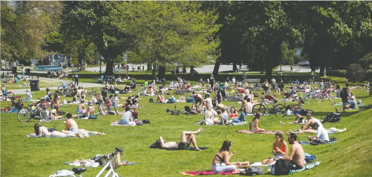  ?? Da rryl Dyck / The Cana dian Pres ?? Despite the fact outdoor areas pose less risk of spreading COVID-19, crowded public beaches, like Kitsilano Beach Park in Vancouver, are a different story, says Dr. Ali S. Raja.