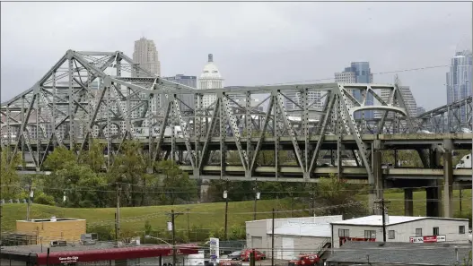  ?? AL BEHRMAN — THE ASSOCIATED PRESS FILE ?? Traffic on the Brent Spence Bridge passes in front of the Cincinnati skyline while crossing the Ohio River to and from Covington, Ky., Oct. 7, 2014. According to a recent announceme­nt by Kentucky and Ohio they will receive more than $1.63billion in federal grants to help build a new Ohio River bridge near Cincinnati and improve the existing overloaded span there, a heavily used freight route linking the Midwest and the South.