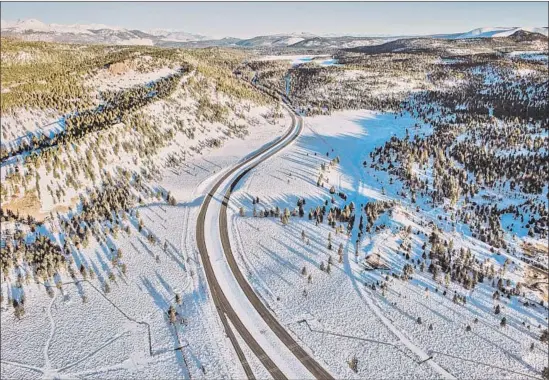  ?? Peter Mourning Mammoth Mountain ?? HIGHWAY 395 winds through the snow-covered Sierra Nevada on Saturday. Snow levels look good now, “but that could change tomorrow,” a state official says.