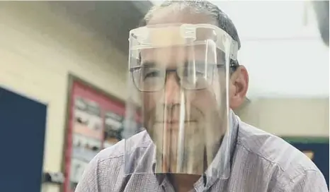  ??  ?? Headteache­r Ian Redford modelling the reusable face shields that the school is producing.