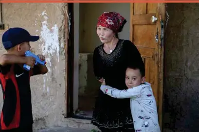  ??  ?? Alif Baqytali hugs his mother, Gulnar Omirzakh, at their new home in Shonzhy, Kazakhstan