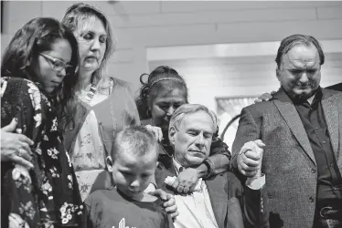 ?? Lisa Krantz / Staff photograph­er ?? Shooting survivors — including, from left, Rihanna Tristan, Julie Workman, Ryland Ward, Farida Brown and David Colbath — join in prayer with Gov. Greg Abbott during the dedication ceremony Sunday for the new building for First Baptist Church of Sutherland Springs.