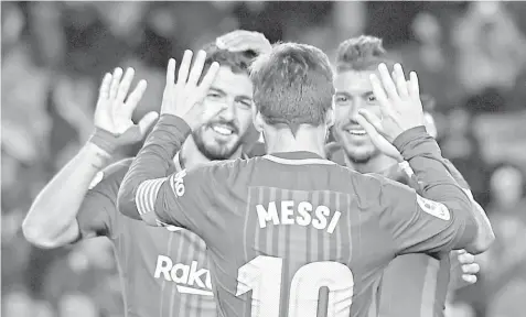  ?? AGENCE FRANCE PRESSE ?? Barcelona's Brazilian midfielder Paulinho (R) celebrates a goal with Barcelona's Argentinia­n forward Lionel Messi and Barcelona's Uruguayan forward Luis Suarez (L) during the Spanish league football match FC Barcelona vs Levante UD at the Camp Nou...