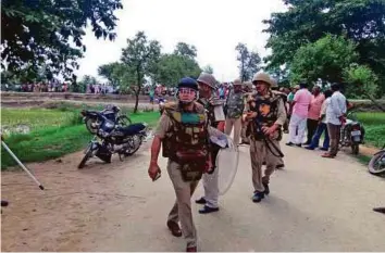  ?? PTI ?? Police at the crime scene after a Dalit couple was hacked to death in Mainpuri in Uttar Pradesh yesterday.