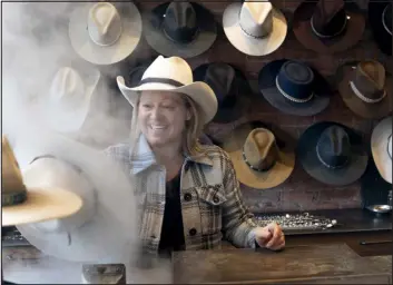  ?? ?? Wendy Kunkle, an owner and president of Kemo Sabe, uses steam to shape a hat at the Western themed store, known for its custom cowboy hats that can cost hundreds of dollars.