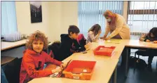  ?? 01_B10hub03, ?? Mrs MacLauchla­n helps one pupil as others look out their work,