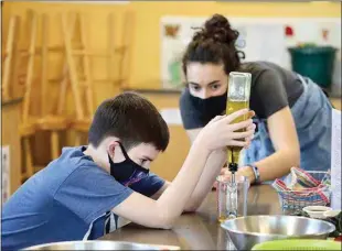  ?? PHOTOS COURTESY GRIMM FAMILY EDUCATION FOUNDATION ?? ABOVE: A student and instructor measure olive oil during a session of the Winter Camp at the Edible Schoolyard Kern County. Enrollment is open now for the Spring Camp, which starts later this month. RIGHT: Students tend the garden during the Winter Camp at the Edible Schoolyard Kern County. Enrollment is open now for the Spring Camp, which starts later this month.