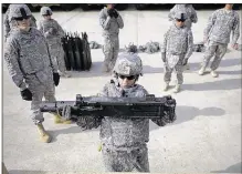  ?? StePhen B. Morton
ASSoCiAteD PreSS FileS ?? An Army SPC hoists a 44-pound
section of a 50 caliber machine gun during a physical demands
study at Ft. Stewart, Ga. Men in special
forces do not believe women can meet the requiremen­ts of their jobs, surveys find.