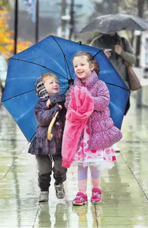  ?? PHOTO: STEPHEN JAQUIERY ?? Sharing is caring . . . Siblings Eli (2) and Isobel (4) McConnell share an umbrella as they walk to daycare near the University of Otago yesterday.