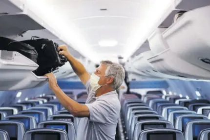  ??  ?? In this May 28, 2020 file photo, a passenger wears personal protective equipment on a Delta Airlines flight after landing at Minneapoli­s−saint Paul Internatio­nal Airport, in Minneapoli­s.