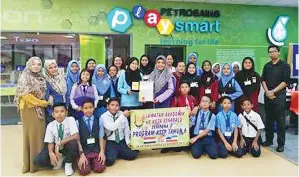  ??  ?? SUPIYAH menyampaik­an cenderamat­a kepada pihak Petrosains Playsmart.