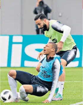  ??  ?? Painful: Kylian Mbappe goes down under a challenge from Adil Rami in training