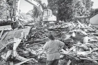  ?? Mark Mulligan / Staff file photo ?? Annie Green looks at the remains of her home after it was demolished last year due to damage from Hurricane Harvey, one of Texas’ 67 major weather disasters from 2010 to 2020.