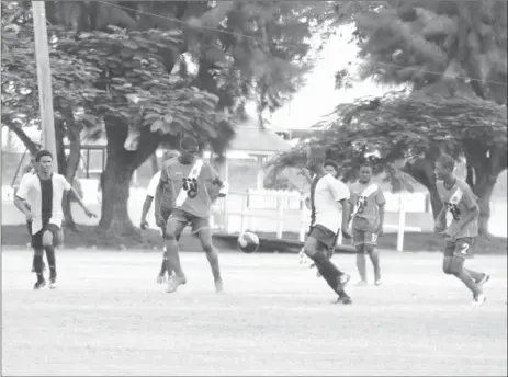  ??  ?? Jeremy Garrett (centre) of Fruta Conquerors in the process of receiving the ball while being pursued by Creek FC opposing player during their u17 matchup at the Camp Ayanganna ground yesterday.