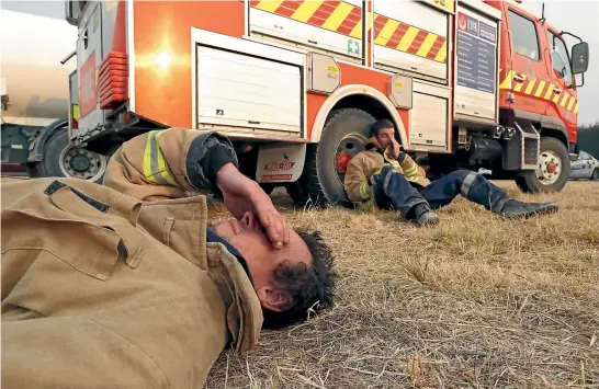  ?? MARTIN DE RUYTER/STUFF ?? Takaka volunteer firefighte­rs Callum Reid, front, Kyle Gardiner and Grant Lawrence are exhausted at the end of their shift fighting the out-of-control forest fire that started in Pigeon Valley.