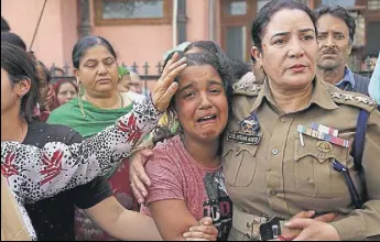  ??  ?? A J&K Police officer consoles the daughter of policeman Deepak Thusoo during his funeral in Jammu on Thursday.