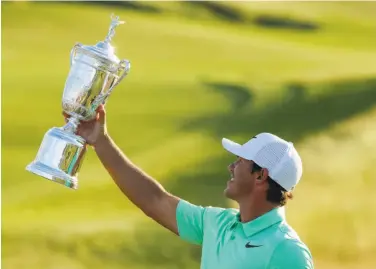  ?? Charlie Riedel / Associated Press ?? Brooks Koepka hoists the trophy after winning the U.S. Open at Erin Hills for his first victory in a major.