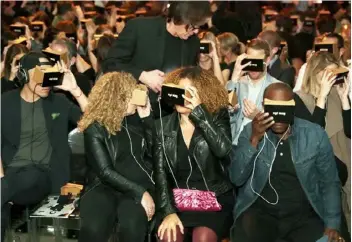  ??  ?? The fold: actor Don Cheadle, right, and others enjoy virtual reality on the cheap with Google Cardboard.