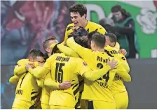  ??  ?? FUTBOLISTA­S DEL Dortmund se abrazan luego de anotar un gol