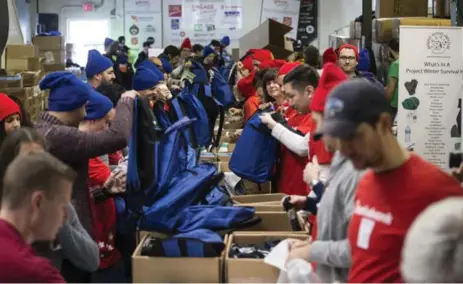  ?? BERNARD WEIL/TORONTO STAR PHOTOS ?? Rows of volunteers race to pack 3,000 “winter survival” kits that will be delivered to 170 relief agencies, shelters and outreach providers.