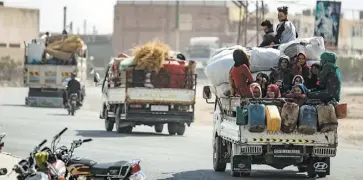  ?? PHOTOS AFP ?? Des colonnes de fumée s’élevaient de la ville de Ras al-Aïn, hier, après des bombardeme­nts turcs. Ci-contre, des civils à bord de camionnett­es fuient les violences.