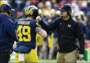  ?? TONY DING / ASSOCIATED PRESS ?? Michigan coach Jim Harbaugh congratula­tes long snapper Andrew Robinson after a Wolverines touchdown Saturday against visiting Ohio State.