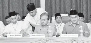  ??  ?? ANIFAH sedang meneliti beberapa kertas kerja sempena mesyuarat perwakilan Pergerakan Pemuda Umno Bahagian Kimanis.