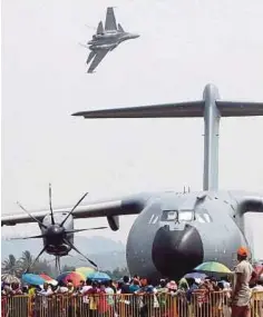  ??  ?? SEBUAH pesawat Sukhoi terbang melintasi pesawat A400M.