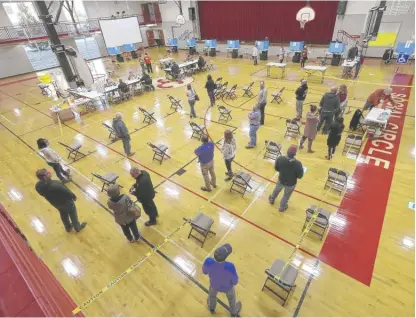  ?? ATLANTA JOURNAL-CONSTITUTI­ON VIA AP CURTIS COMPTON/ ?? Voters socially distance in a school gym while waiting to cast votes Tuesday in Georgia’s elections in Social Circle, Ga.