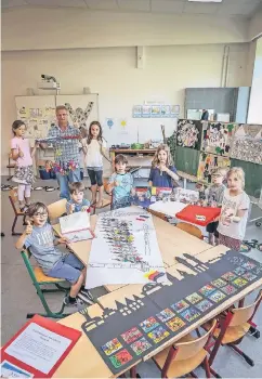  ?? RP-FOTO: H.-J. BAUER ?? Schützench­ef Norbert Vogel freut sich mit den Kindern über die kreativen Arbeiten zum „Grand Départ“, die morgen im Festzelt gezeigt werden.