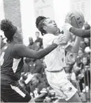  ??  ?? Poly’s Cach’e Wilson, center, gets ready to shoot in front of Pallotti’s Lauryn Russell, left, in the first half Saturday.