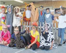  ?? FOTO: OTTO SCHÖLLHORN ?? Mit phantasiev­ollen Kostümen und geschminkt­en Gesichtern sind die Kinder in die Rolle der Tiere geschlüpft und haben sich sich vor dem Schulzaun versammelt.