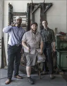  ??  ?? Blacksmith Jesse Robinson, centre, with apprentice­s Clifford Hackworth, left, and Troy Stevens. Robinson, who opened his Hyattsvill­e, Md., shop in 2012, recently shifted his designs from organic to machinelik­e design.