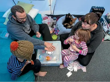  ?? PHOTO: ALDEN WILLIAMS/FAIRFAX NZ ?? Rob Campbell, left and Leah Greenwood, play snap with their children Will Campbell, 7, and Bonnie Campbell, 5, while camping at Spencer Beach Holiday Park on Monday.