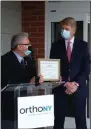  ??  ?? State Sen. Jim Tedisco, left, presents a citation to OrthoNY president Dr. George Silver.