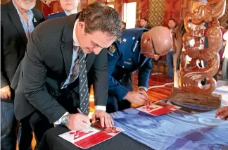  ?? HANNAH ROSS/STUFF ?? Police Minister Stuart Nash and NZ Police acting commission­er Michael Clement sign the contract of blessing.
