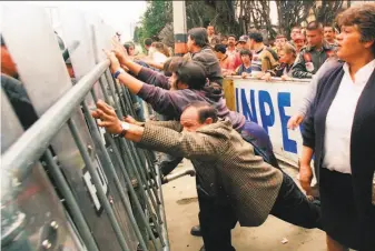  ?? Ariana Cubillos / Associated Press ?? Family members of inmates press against a police barricade outside El Modelo federal prison in Bogota in April after rioting broke out. Human Rights Watch says 24 prisoners were killed.