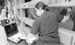  ??  ?? Dr. Natalie Mylniczenk­o, a Disney veterinari­an who has been involved with the care of pregnant white rhinos Kendi, Jao and Lola, performs an ultrasound on Kendi.