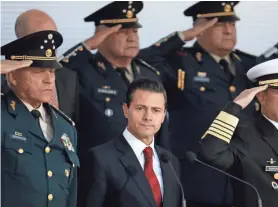  ?? REBECCA BLACKWELL/AP ?? Mexico’s President Enrique Pena Nieto is surrounded by saluting military officers during the annual commemorat­ion of the “March of Loyalty” at Chapultepe­c Castle in Mexico City on Feb. 9. With the president are Defense Secretary Salvador Cienfuegos...
