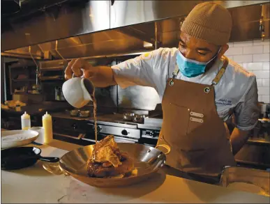  ?? PHOTOS BY JOSE CARLOS FAJARDO — STAFF PHOTOGRAPH­ER ?? Chef Joseph L. Paire III adds a final drizzle of toasted almond syrup to his buttermilk fried chicken topped with candied pancetta.