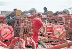  ?? Steve Gonzales / Houston Chronicle file ?? A Halliburto­n employee works near hydraulic fracturing pumping units at a three-pad in the Permian Basin.