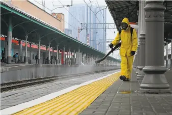  ?? Natalia Kolesnikov­a / AFP / Getty Images ?? A safety worker disinfects Moscow’s Belorussky railway station Friday. The city has set new restrictio­ns to fight daily virus infections, which have more than doubled in the past week.
